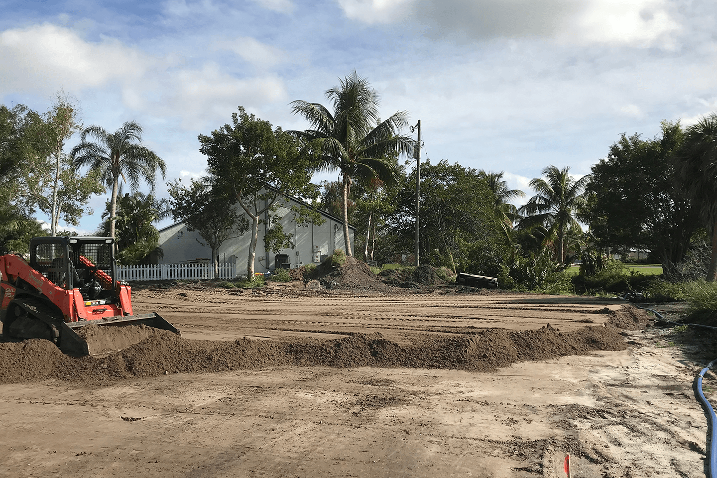 Kubota skid steer moving dirt on a building pad