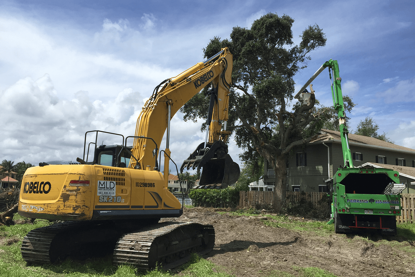 Excavator and bucket truck clearing trees
