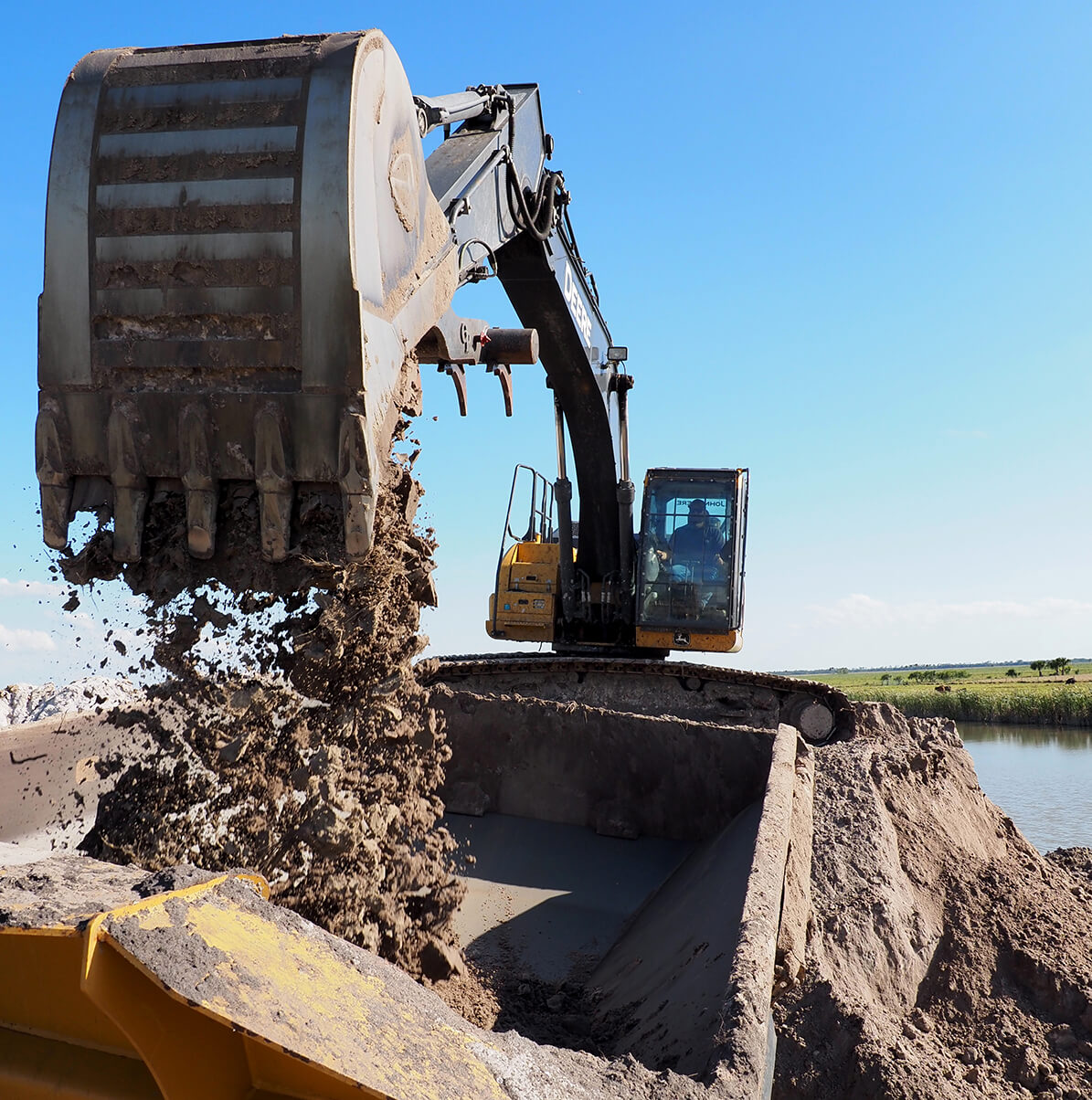 Murray Land Development owner Shawn Murray standing in front of a yellow Case excavator